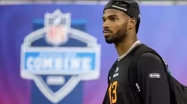 NFL Combine mein ek khiladi, peechhe background mein NFL Combine ka logo dikh raha hai.